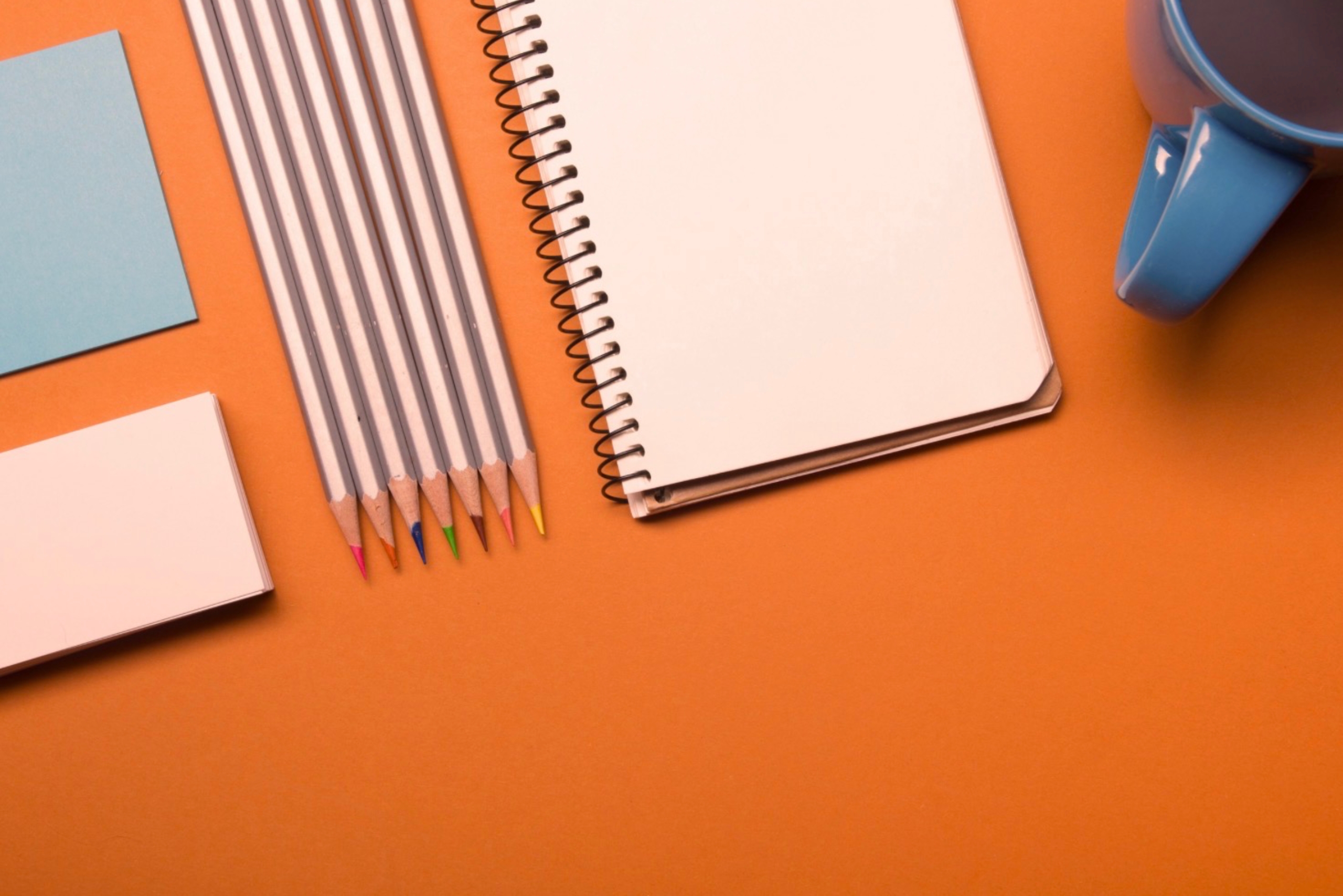 Zu sehen sind ein Notizheft, Stifte und Post it's.